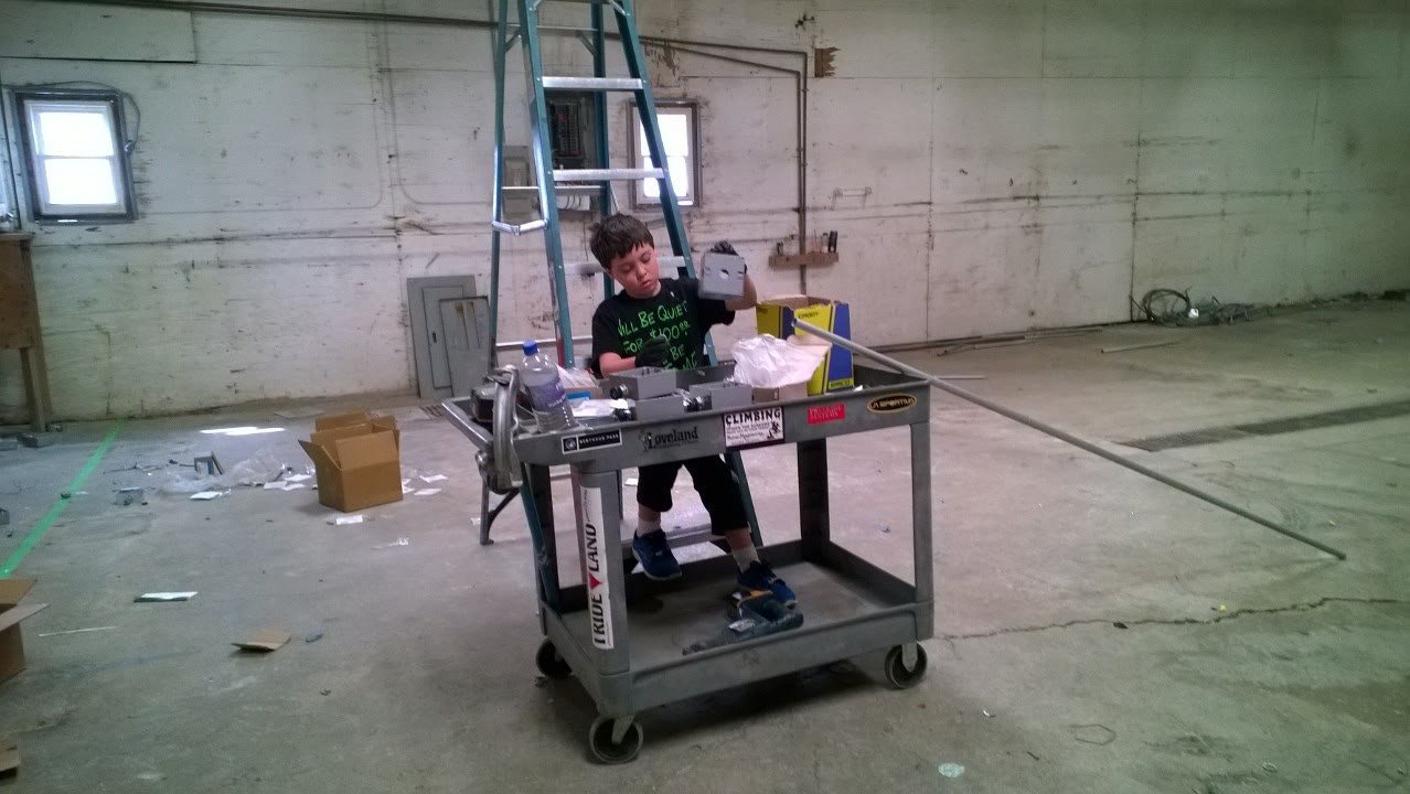 Chris's son working at a job cart in an empty warehouse